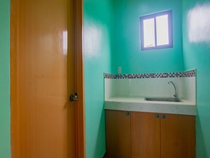 A bathroom with a sink, a window, and a door.