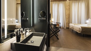A hotel room with a large mirror, a sink with toiletries, a bed, a small table with a chair, and a decorative ceiling. - One Shot Mercat (Valencia)