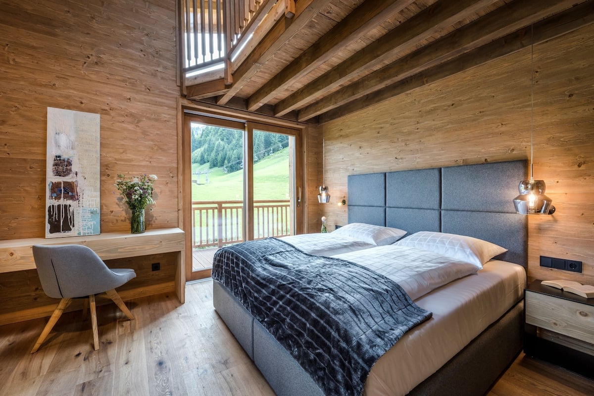 Un dormitorio moderno con una cama grande, un escritorio y una silla.