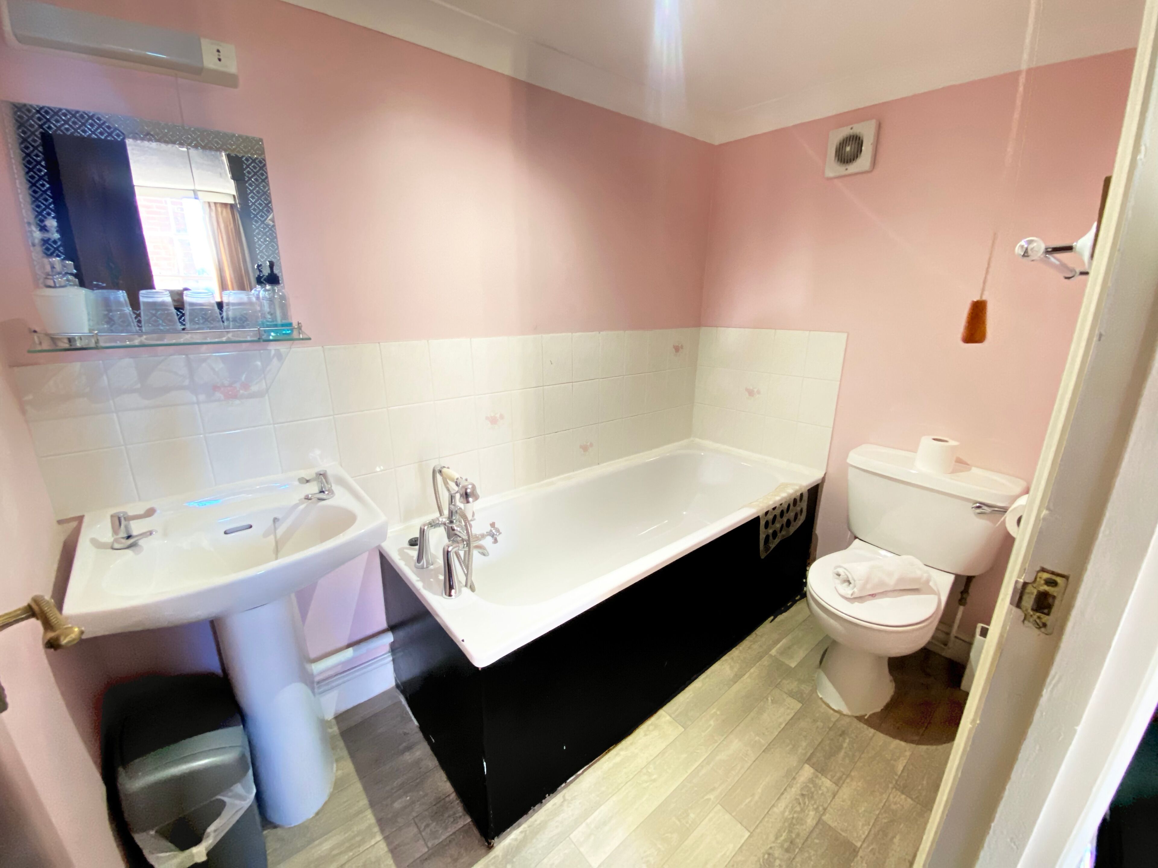 Ein Badezimmer mit Waschbecken, Badewanne, Toilette und Spiegel.