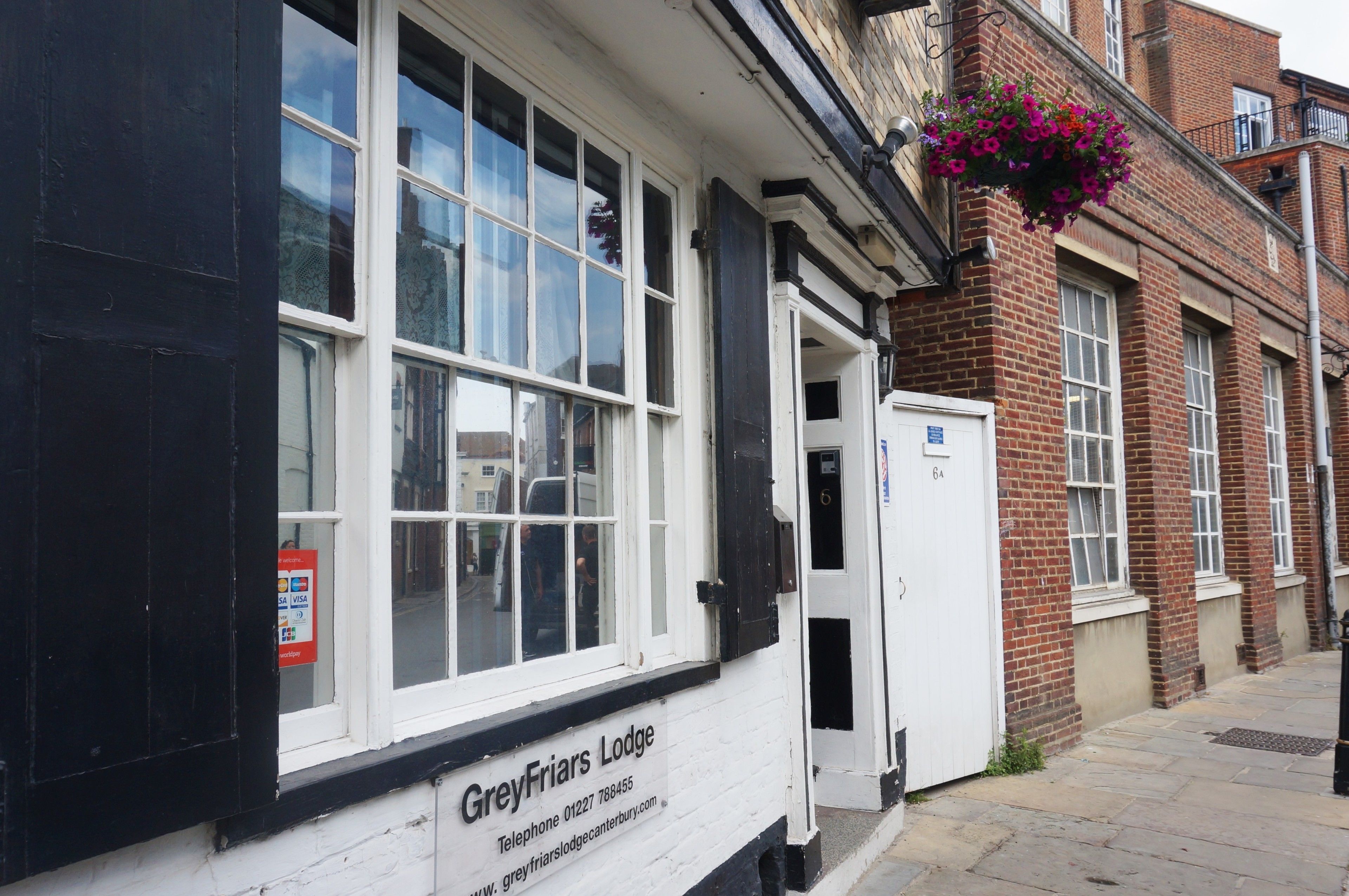 A building with a sign reading "Greyfriars Lodge" and a contact number.