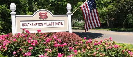 Bordje van Southampton Village Motel met een Amerikaanse vlag en een bloembed in de voorgrond.