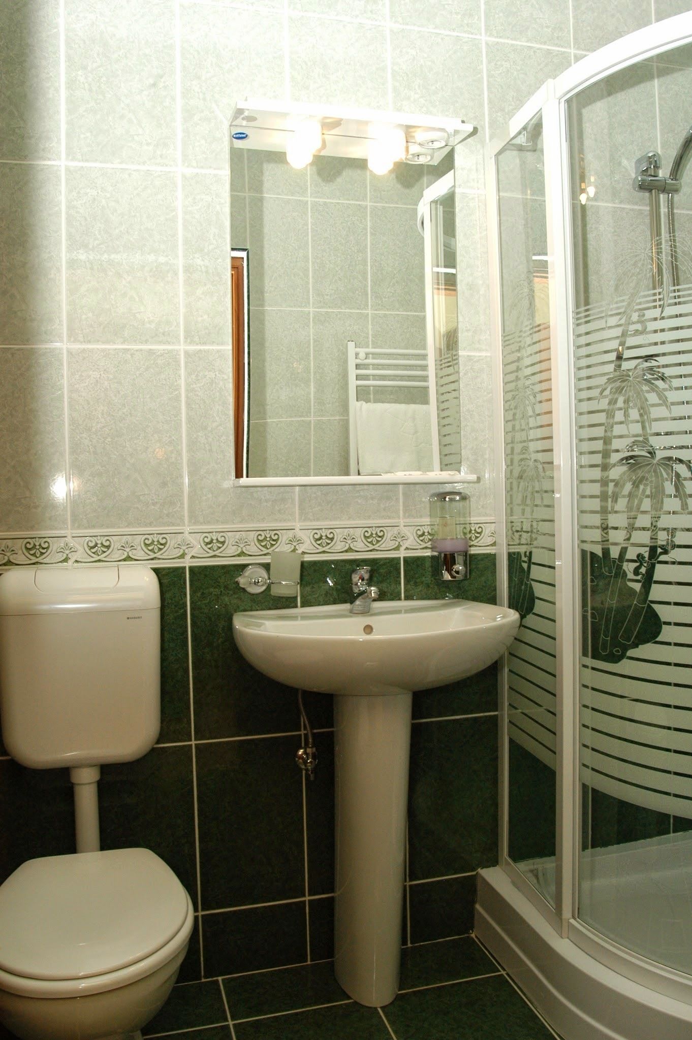 A bathroom with a toilet, sink, and shower.