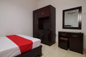 A bedroom with a bed, a wardrobe, a desk, and a mirror.