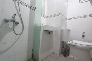A bathroom with a toilet, a shower, and a sink. - RedDoorz @ Turangga Sari (Depok)