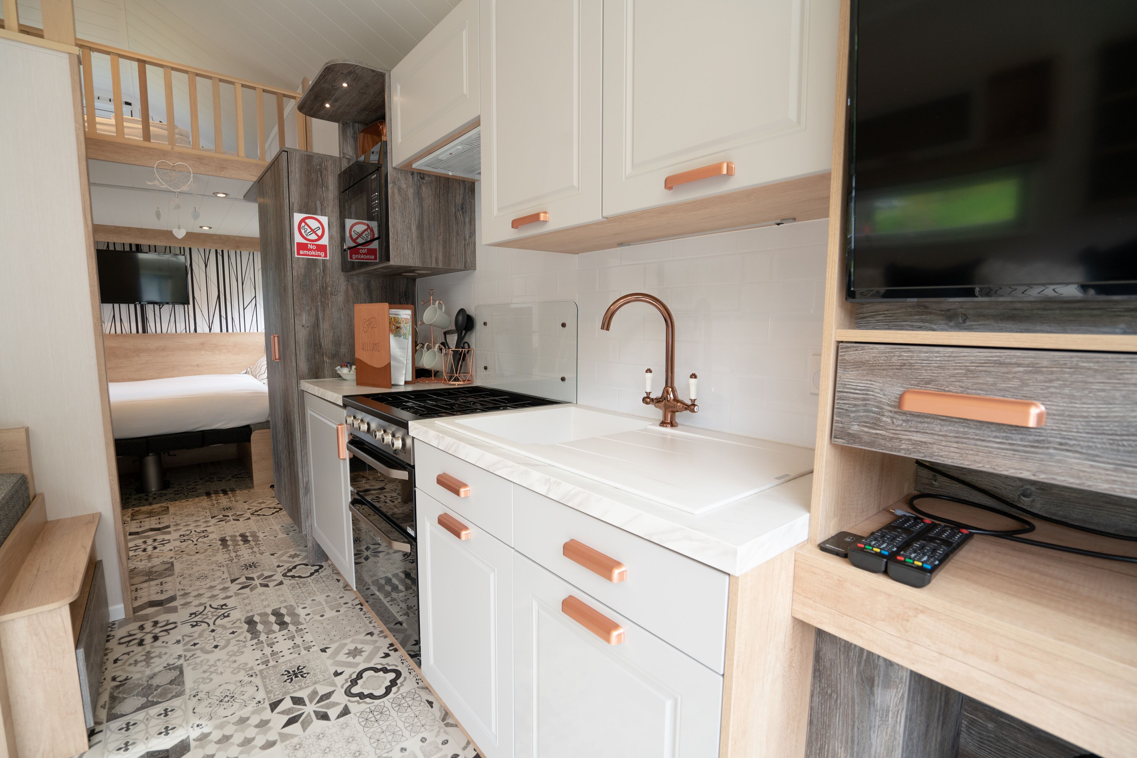 A compact kitchen with white cabinets, a stainless steel stove, and a wooden countertop.