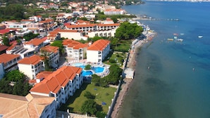 A coastal hotel with multiple buildings, a swimming pool, and a beach with umbrellas. - Porto Iliessa by GHH (Zakynthos)