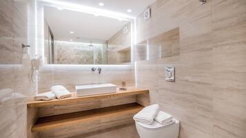 A modern bathroom with a wooden vanity, a large mirror, and a toilet.