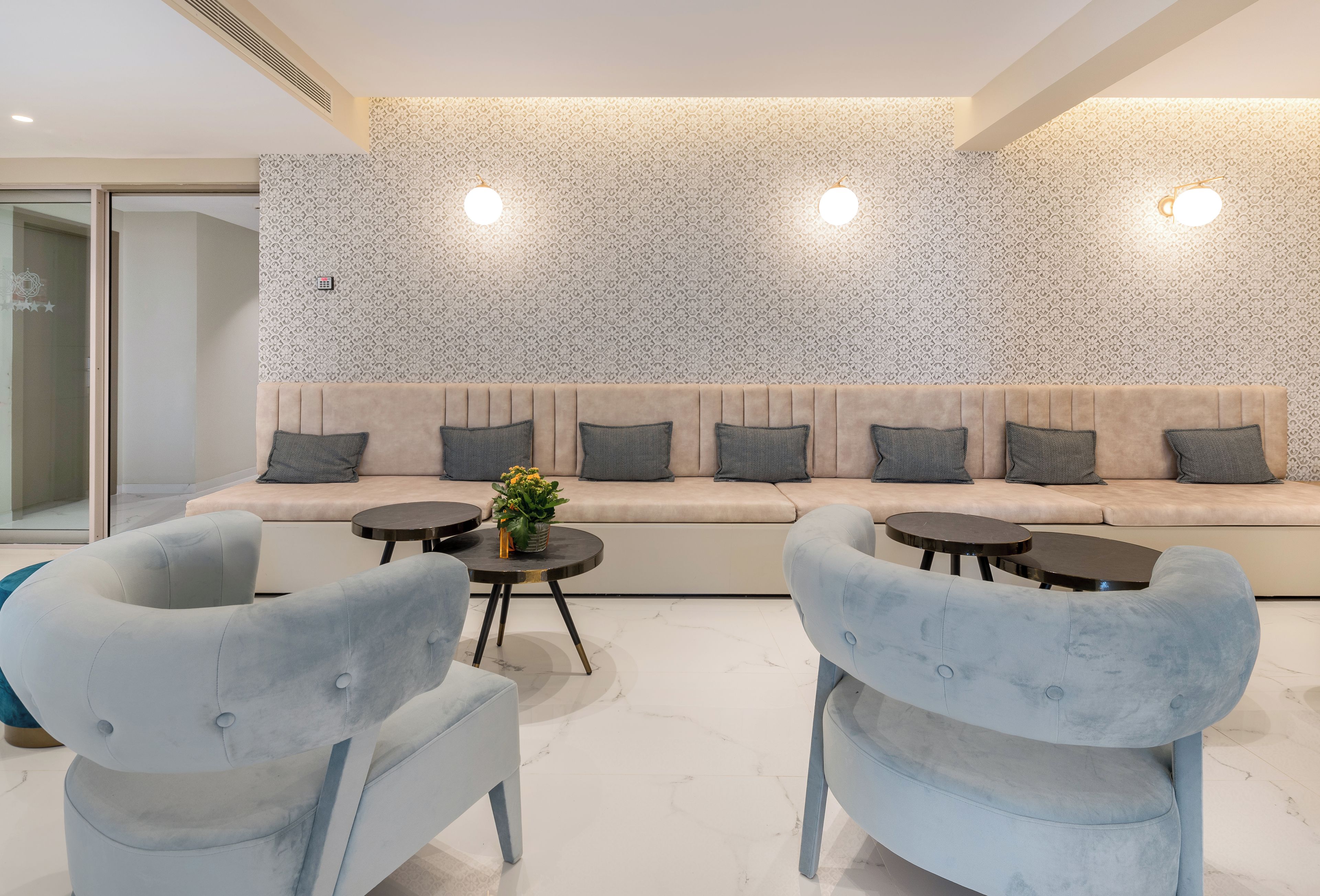 A modern living room with a sofa, two armchairs, and a coffee table.