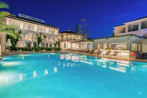 Un hôtel doté d’une piscine, d’un espace extérieur aménagé et d’un bar.