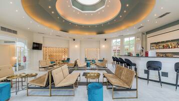 Ein stilvoller Lounge-Bereich mit Sofas, Tischen und einer Bar.