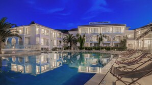 Un hotel con piscina, varios balcones y cielo despejado.