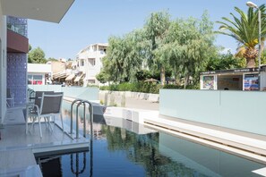 A swimming pool with a view of a cityscape, including buildings and trees. - Tarra Seaside Hotel (Apokoronas)