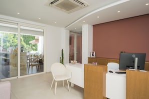 A reception area with a desk, computer, and seating. - Tarra Seaside Hotel (Apokoronas)