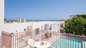 A balcony with a pool, white walls, and air conditioning units. - Tarra Seaside Hotel (Apokoronas)