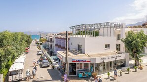 A coastal street with a hair salon and a market. - Tarra Seaside Hotel (Apokoronas)
