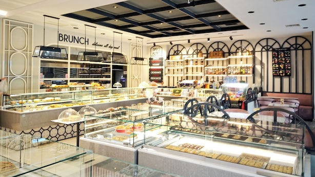 A bakery with glass display cases filled with pastries and a sign that reads 'BRUNCH'. - Art Gallery Hotel (Athens)