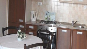 Une cuisine équipée d’une cuisinière, d’un évier, de placards et d’une table à manger avec des chaises.