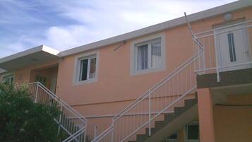 A multi-story building with a staircase, windows, and a door.