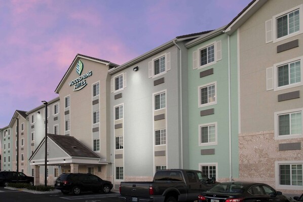Un hotel de varios pisos con un cartel que dice "Woodspring Suites".