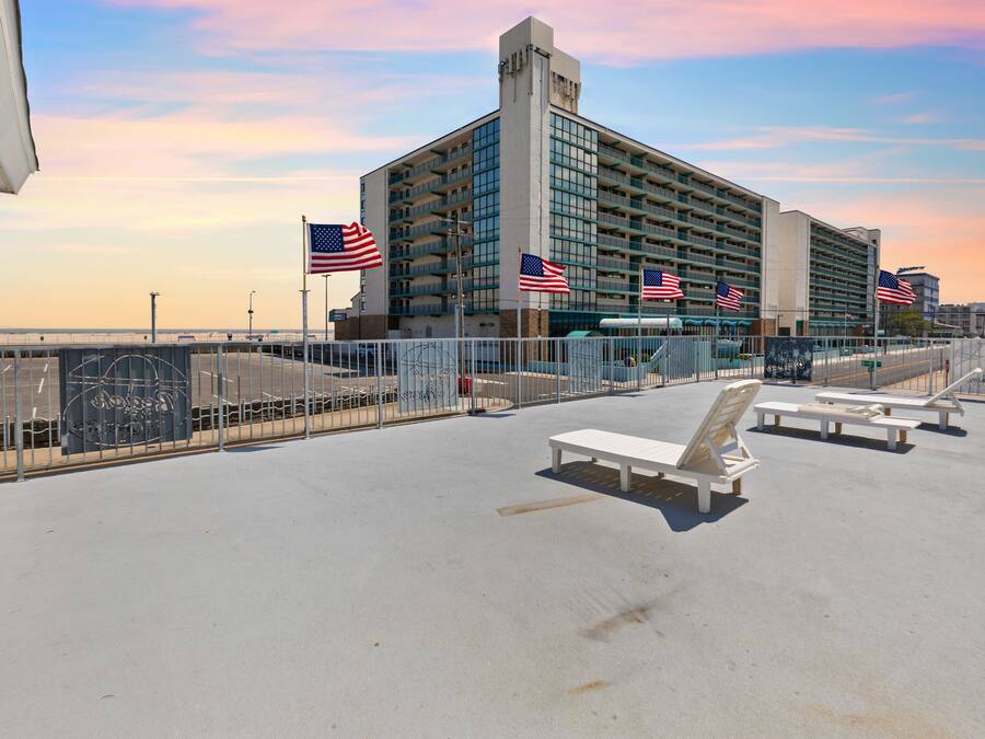 Eine Dachterrasse mit amerikanischen Flaggen, ein großes Gebäude im Hintergrund und Blick auf das Wasser.