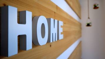 Pared de madera con la palabra “HOME” en letras blancas grandes.