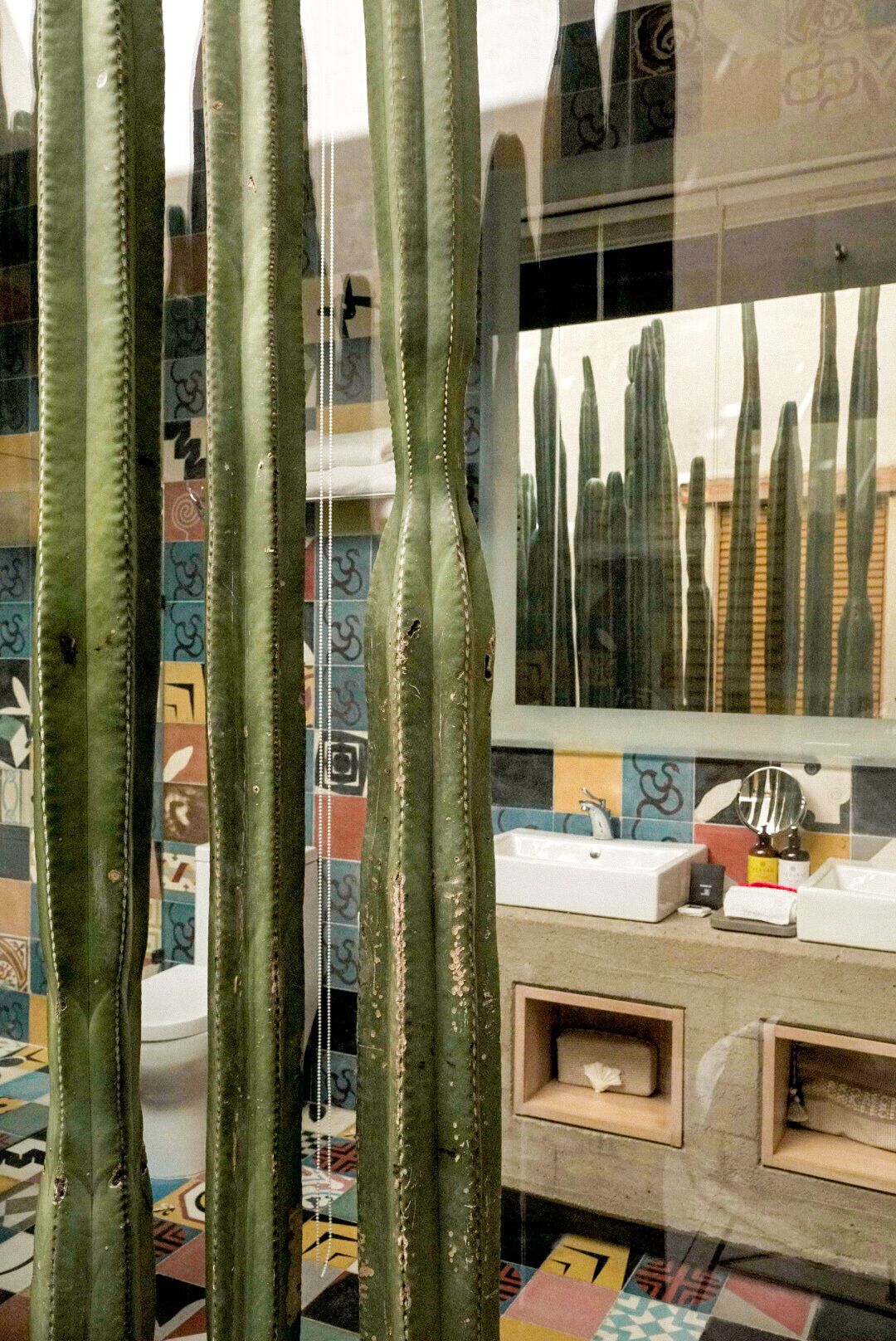 A bathroom with a mirror, sink, and decorative tiles.