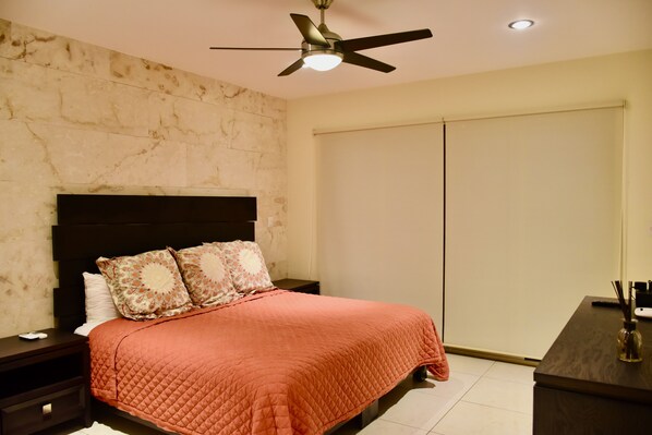 A bedroom with a bed, a nightstand, a desk, a ceiling fan, and a wardrobe. - El Cielo by Casago (Playa del Carmen)