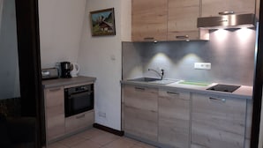 Cocina compacta con horno integrado, lavamanos y extractor Bosch.