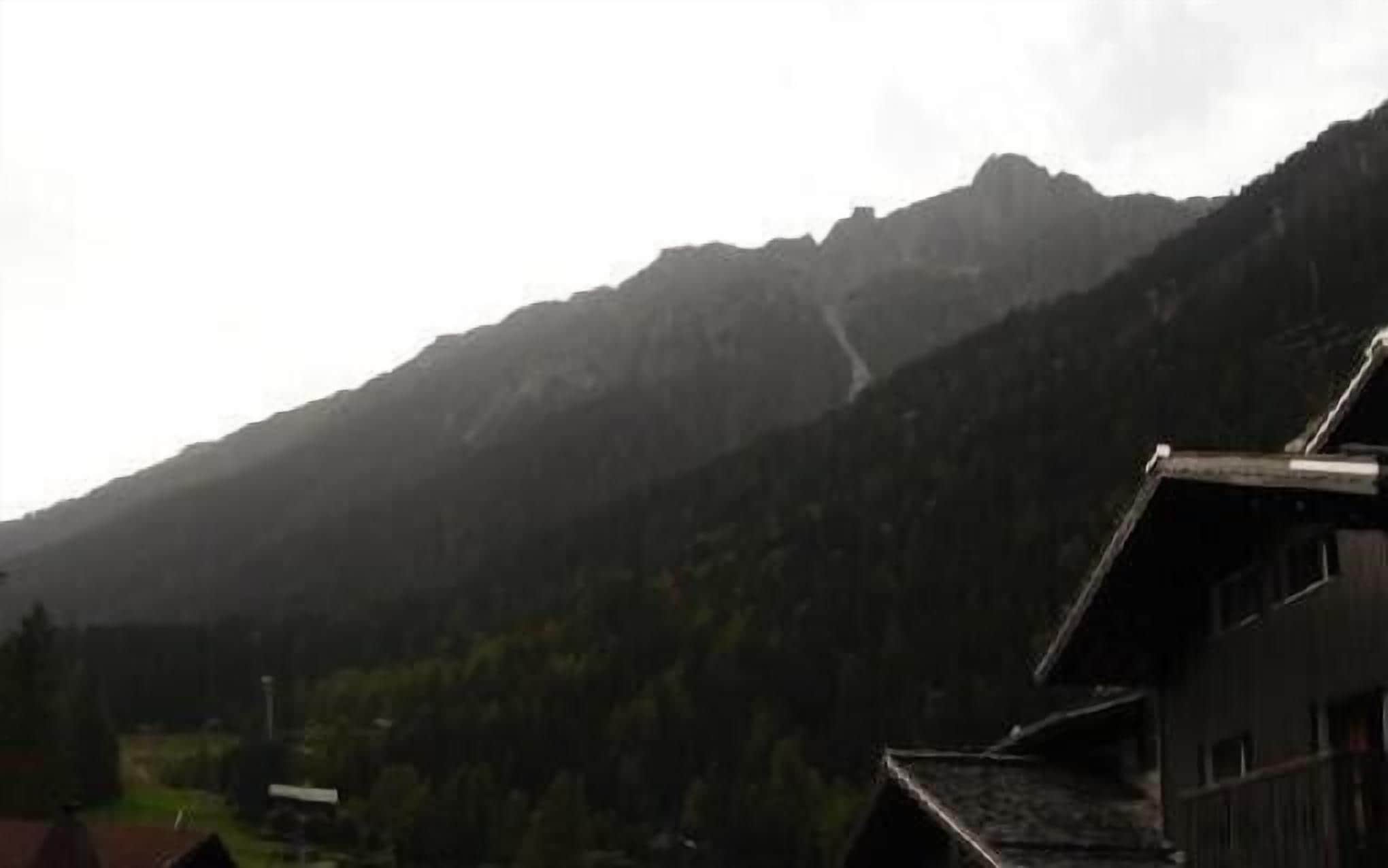 Un paysage de montagne avec un bâtiment au premier plan.