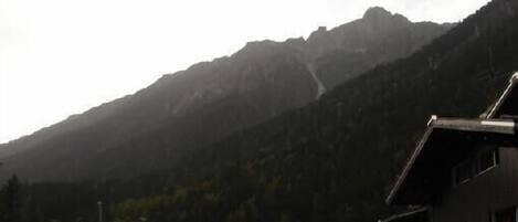 Un paysage de montagne avec un bâtiment au premier plan.