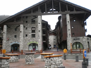 A stone building with a wooden overhang, a sign reading "POIVRE BLAN," and a "Columbia" sign on the right. - Apartment, sleeps 6, downtown, mountain proximity, Val-d'Isère (Val-D'isère)