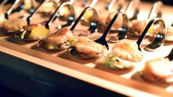 A row of seafood appetizers on a wooden serving board.
