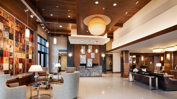 A modern lobby with a reception desk, seating area, and artwork on the walls.