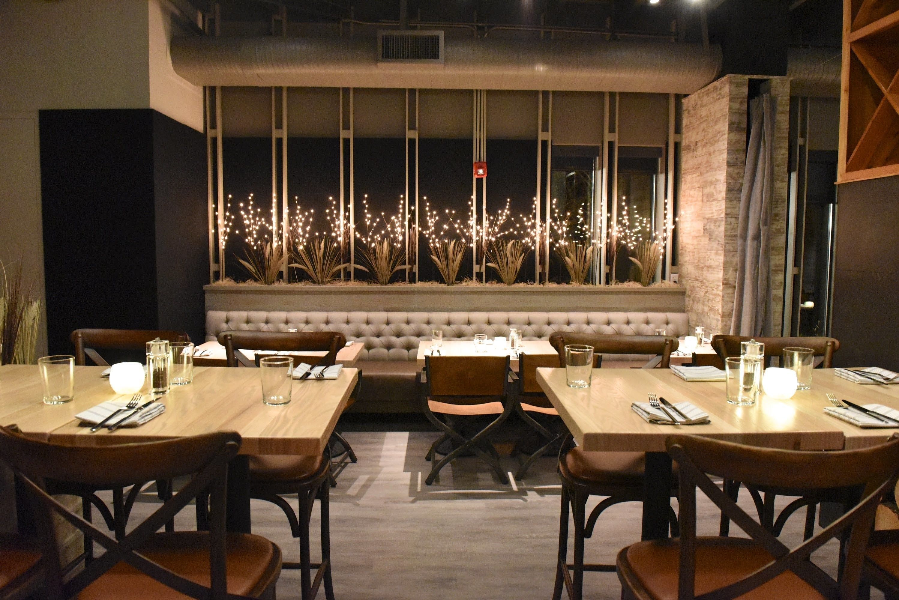 A restaurant with a long table, chairs, and a bench.