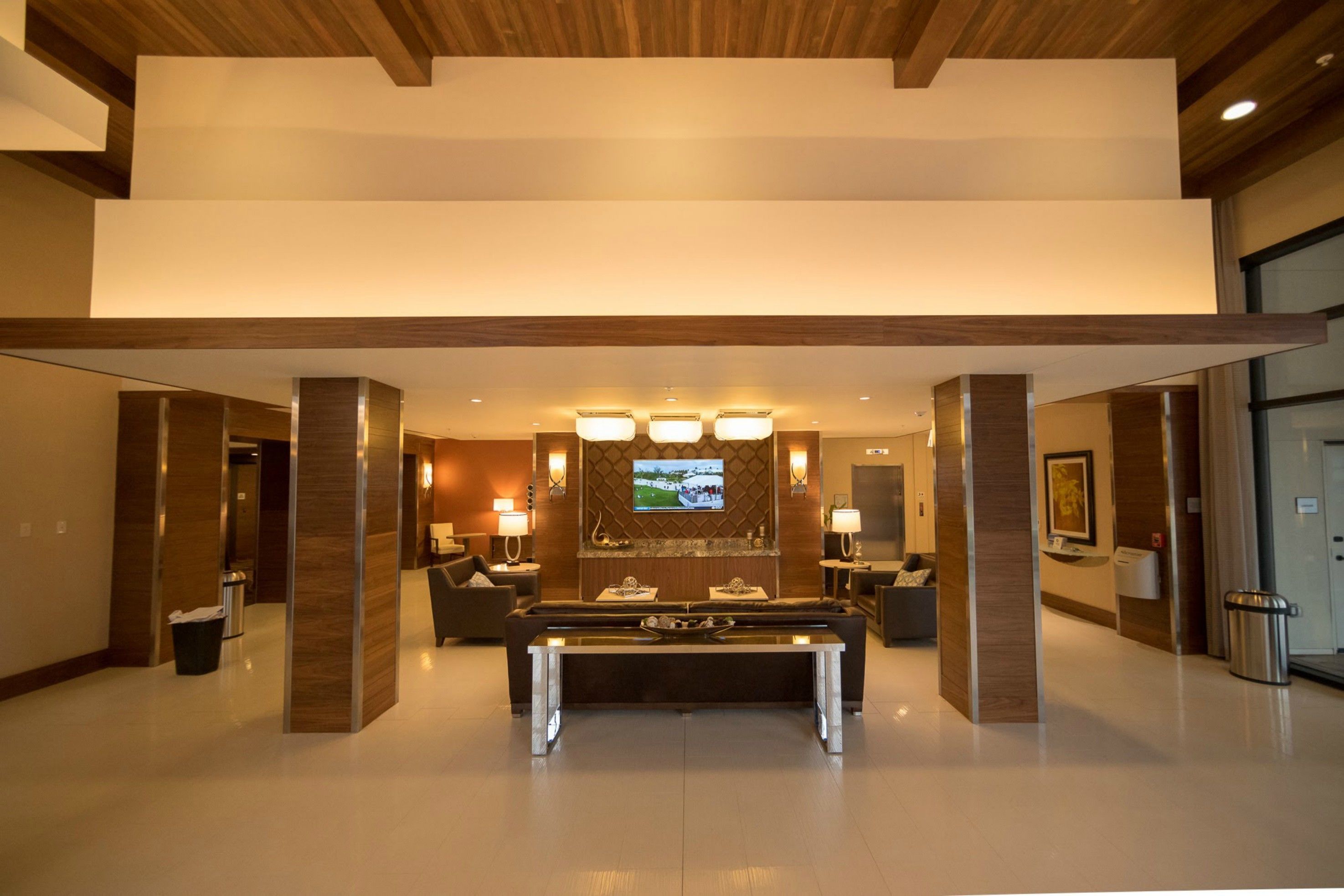 Um lobby moderno com mesa de bilhar, assentos confortáveis e uma televisão na parede.