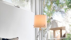 Et hyggeligt soveværelse med seng, natlampe, udsigt til det fri og et vindue.