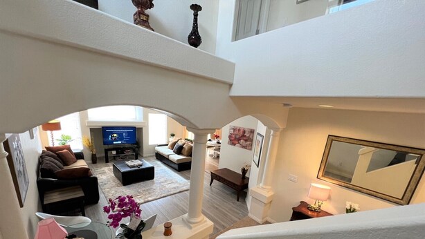 A spacious living area with a sofa, coffee table, and TV. A staircase leads to an upper level. - Close strip 3 bedroom Home (Las Vegas,)
