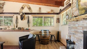 Ein rustikales Interieur mit einem Holzfass, Ledersitzmöbeln und verschiedenen Dekorationen an den Wänden.