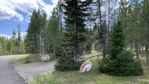 A gravel path curving through a forest with two large white and red wheels.