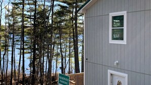 A building with a sign indicating reserved parking for cozy haven guests. - Cozy Haven: A Lakeside Cottage Near Acadia (Orland)