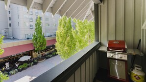 Un balcón con una parrilla y vistas a un restaurante abajo.