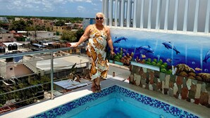 A person standing by a swimming pool with a mural of marine life on the adjacent wall. - Maria Bonita, Locate Near The Center Of The Higuey City (Higüey)