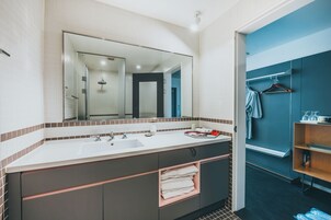 Un baño moderno con un espejo grande, lavamanos dobles y un perchero para toallas.