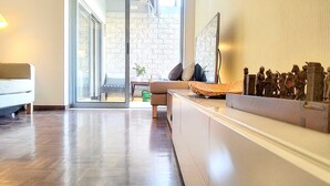 A modern living room with a sofa, a coffee table, and a decorative shelf with figurines.