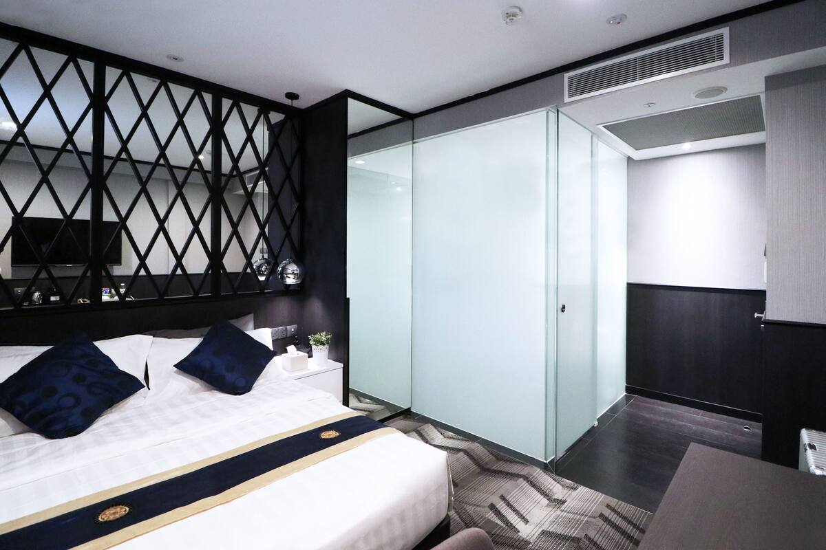 Une chambre d’hôtel moderne équipée d’un lit, d’un bureau, d’une armoire et d’un téléviseur.