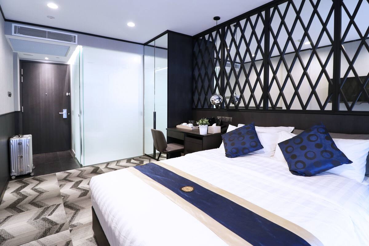 Une chambre d’hôtel moderne, dotée d’un grand lit, d’un bureau et d’un coin salon.