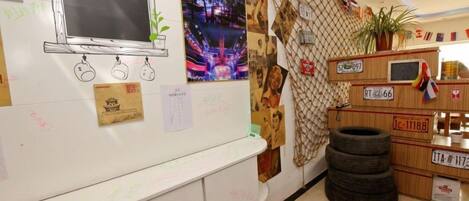 Una habitación con un tablero antiguo, una pared con fotografías y una exhibición de neumáticos.