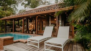 Una piscina al aire libre, tumbonas