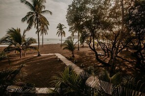 På stranden, sort sand, solsenger og strandhåndklær